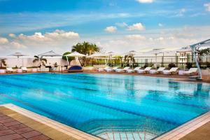 a swimming pool with chairs and umbrellas on a building at Hilton Colombo Residence in Colombo