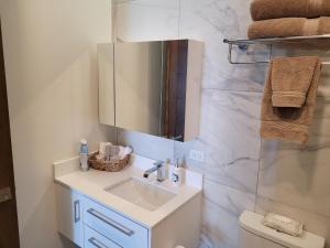a bathroom with a sink and a mirror at Seafront Condo Pool and Jacuzzi in Rosarito