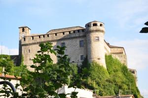 a large castle sitting on top of a hill at Apartment Montebello in Parma