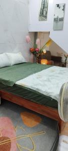 a bedroom with a bed with a green and white comforter at H2Homestay phố cổ check in tự động in Hanoi