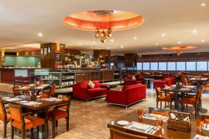 a restaurant with tables and chairs and a bar at Hilton Garden Inn New Delhi/Saket in New Delhi