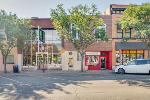 a building on a street with a white car parked in front at Downtown Montrose Apartment 12 Mi to Natl Park! in Montrose