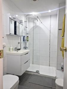 een witte badkamer met een douche en een toilet bij Fresh and bright apartment next to the beach PE210 in Arona