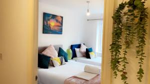 a room with two beds and a plant at Mayfair - Duplex Relocations in Wakefield