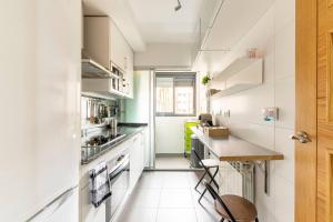 una pequeña cocina con armarios blancos y una encimera en Home Sweet Home, en Madrid