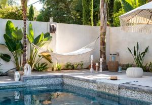 a swimming pool with a hammock in a backyard at Cali Luxury Dream Hideaway in Woodland Hills