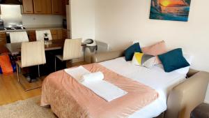 a large bed in a room with a kitchen at Mayfair - Duplex Relocations in Wakefield