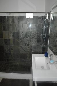 Apartment No 18 - West Terraces في فليك-إن-فلاك: حمام مع حوض ودش مع باب زجاجي