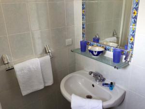uma casa de banho com lavatório, espelho e toalhas em Hotel Villa Tokur em Datça