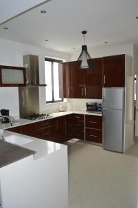 Apartment No 18 - West Terraces في فليك-إن-فلاك: مطبخ مع خزائن خشبية وثلاجة من الفولاذ المقاوم للصدأ