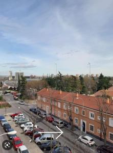 un aparcamiento con coches estacionados frente a los edificios en HABITACIÓN PRIVADA EN PISO a 10 minutos de Atocha, en Madrid