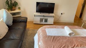 ein Wohnzimmer mit einem Sofa und einem Flachbild-TV in der Unterkunft Mayfair - Duplex Relocations in Wakefield