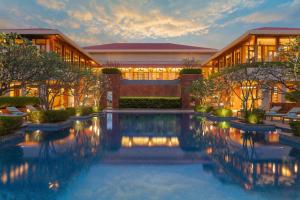 a hotel with a pool in front of a building at Hilton Goa Resort Candolim in Candolim