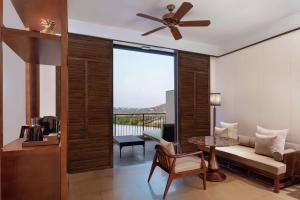 een woonkamer met een bank en een plafondventilator bij Hilton Goa Resort Candolim in Candolim