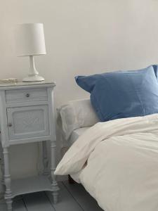 een bed met een nachtkastje en een lamp op een bijzettafel bij La Petite Fanny in Étretat