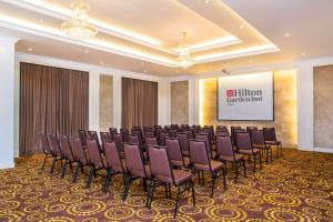 a conference room with purple chairs in front of a screen at Hilton Garden Inn Hanoi in Hanoi