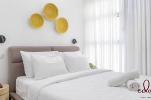a bedroom with a white bed with white pillows and a window at דירה משפחתית במתחם סי סייד - By Edomlux in Eilat +11 photos