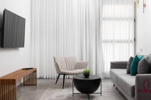 a living room with a couch and a chair at דירה משפחתית במתחם סי סייד - By Edomlux in Eilat
