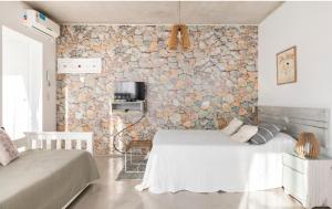 a bedroom with two beds and a stone wall at Luminoso y comfortable monoambienteA 25 minutos de Ezeiza in Remedios de Escalada