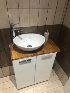 biała umywalka na drewnianym blacie w łazience w obiekcie Domek Pod Skałkami w mieście Idzików