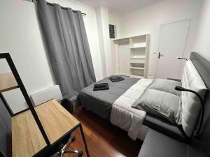 a small bedroom with a bed and a chair at Appartement entier proche de Paris. in Pavillons-sous-Bois
