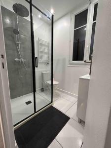 a white bathroom with a shower and a toilet at Appartement entier proche de Paris. in Pavillons-sous-Bois