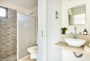 een badkamer met een wastafel, een toilet en een spiegel bij Luminoso y comfortable monoambienteA 25 minutos de Ezeiza in Remedios de Escalada