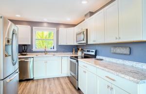 a white kitchen with white cabinets and a window at Henderson home in Sanibel