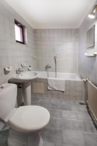 a bathroom with a toilet and a sink and a tub at Pension Clara in Karlovy Vary