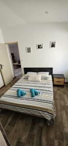 um quarto com uma cama grande e almofadas azuis em Appartement Kantar - Tout en Rose em Anduze