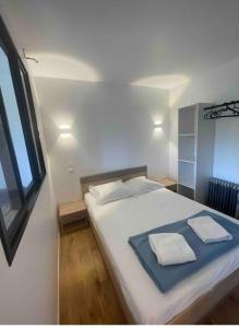 um quarto com uma cama grande com duas toalhas em Porticcio avec Piscine proche plage em Porticcio