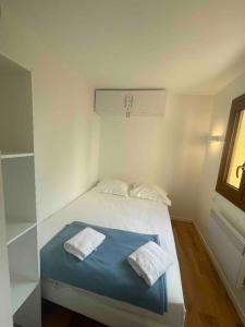 um quarto com uma cama com duas toalhas em Porticcio avec Piscine proche plage em Porticcio