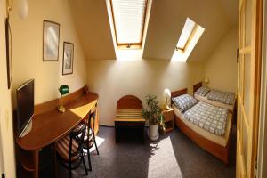 Habitación pequeña con 2 camas, escritorio y escritorio. en Hotel Babí lom, en Lelekovice