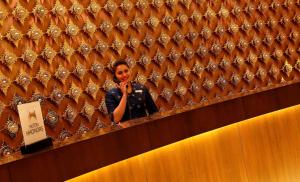 a woman talking on a cell phone in front of a mirror at Hilton Jaipur in Jaipur