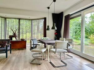 a dining room with a table and chairs at Vakantiehuis Bos en Hei Veluwe in Epe