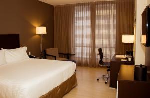 a hotel room with a bed and a desk and chair at Holiday Inn Panama Distrito Financiero, an IHG Hotel in Panama City