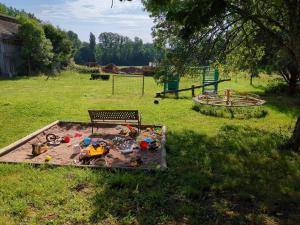 a play area with a bench and toys in a field at Climatisé, piscine chauffée et parking fermé in Brignac-la-Plaine