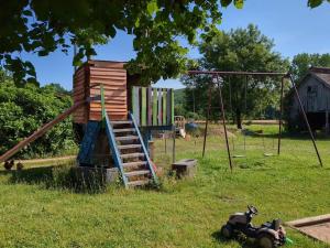 a playground with a slide and a swing at Climatisé, piscine chauffée et parking fermé in Brignac-la-Plaine