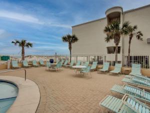 un patio con sillas y mesas y una piscina en San Carlos 1604 by Vacation Homes Collection, en Gulf Shores