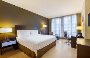 a hotel room with a large bed and a desk at Holiday Inn Panama Distrito Financiero, an IHG Hotel in Panama City