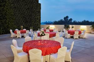ラクナウにあるHilton Garden Inn Lucknowの赤白のテーブルクロス付きテーブルと椅子