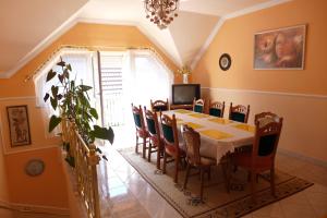 uma sala de jantar com mesa e cadeiras em Caty Vendégház em Hajdúszoboszló