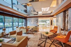 a lobby with chairs and tables and windows at Hilton Garden Inn Lucknow in Lucknow