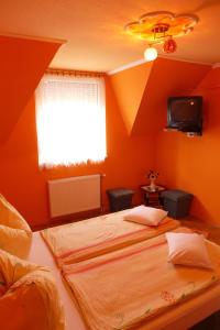 A bed or beds in a room at Caty Vendégház