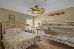 a bedroom with two bunk beds and a ceiling fan at Sail House East by Vacation Homes Collection in Gulf Shores