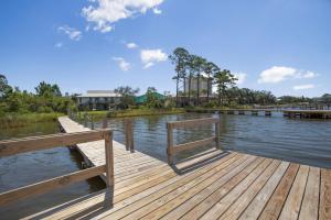 a wooden dock with a bench on the water at Sail House East by Vacation Homes Collection in Gulf Shores