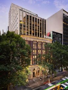 un edificio alto en una ciudad con una calle en Hilton Melbourne Little Queen Street, en Melbourne