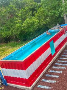 une grande piscine décorée dans des tons rouges blancs et bleus. dans l'établissement Casa Garfio, à Barra de Navidad