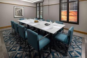 une salle de conférence avec une grande table et des chaises dans l'établissement Hilton Melbourne Little Queen Street, à Melbourne