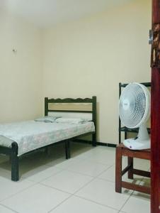Schlafzimmer mit einem Bett und einem Ventilator auf einem Tisch in der Unterkunft Casa em Paracuru Beach in Paracuru
